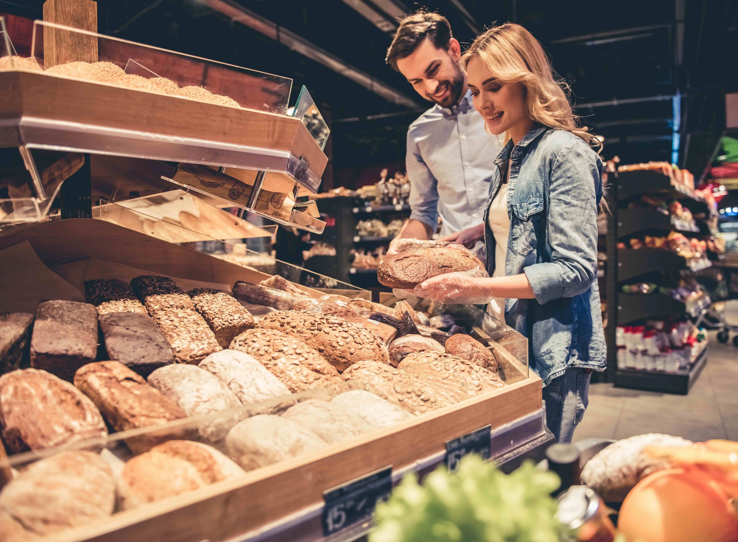 Femme et homme dans un supermarché devant le rayon du pain